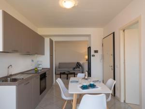 een keuken en een woonkamer met een witte tafel en stoelen bij Apartment Rosmarino by Interhome in Chiappa