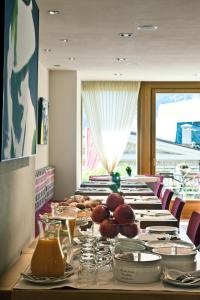 uma mesa longa com pratos de comida em Hotel Meublè Sertorelli Reit em Bormio