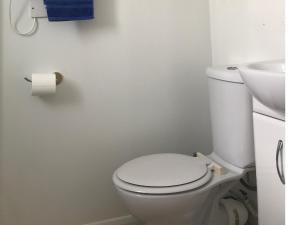 een witte badkamer met een toilet en een wastafel bij Brighton Marina Floating home in Brighton & Hove
