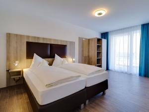 een slaapkamer met een groot bed en een groot raam bij Apartment Ankerplatz by Interhome in Großpösna