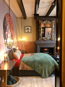 1 dormitorio con cama, espejo y chimenea en Slapen bij Café de Concurrent en Vlissingen