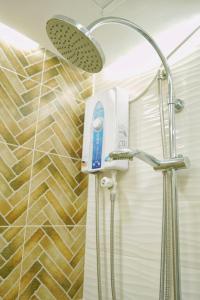 La salle de bains est pourvue d'une douche avec un pommeau de douche. dans l'établissement Topaz 1 Bedroom Suite Orochi Staycation PH at Centrio Towers, à Cagayán de Oro