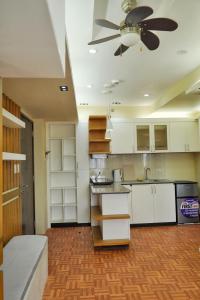 a kitchen with white cabinets and a ceiling fan at Topaz 1 Bedroom Suite Orochi Staycation PH at Centrio Towers in Cagayan de Oro