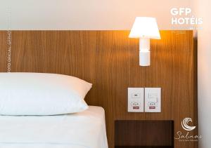 a bedroom with a bed and a light on a wall at SALINAS EXCLUSIVE - GAV Resorts in Salinópolis