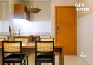 uma cozinha com mesa e cadeiras e uma porta de madeira em SALINAS EXCLUSIVE - GAV Resorts em Salinópolis