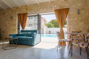 a living room with a blue couch and a pool at Amoroza Villa in Nydri