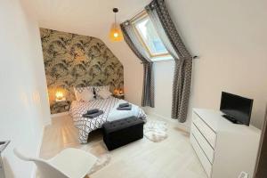 a bedroom with a bed and a tv in it at La Forgette - Netflix - Cosy in Les Pieux