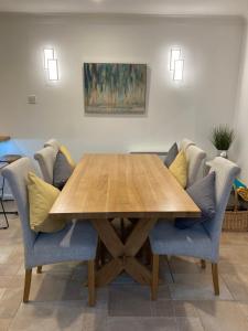 a dining room table with chairs and a wooden table at Hollyhocks Holiday Home-Luxury ground floor 2 bedroomed apartment sleeps 5 in Ivybridge