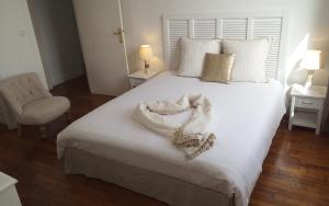1 dormitorio con 1 cama con sábanas blancas y silla en Appartement vue mer Brest hyper centre en Brest