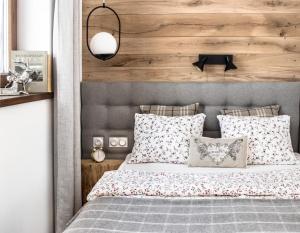 a bedroom with a bed with a wooden wall at Apartament Gorsky in Poronin