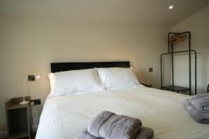 a bedroom with a white bed with towels on it at 24 Tanners Yard in Kendal