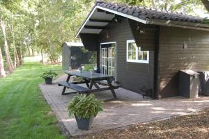 een picknicktafel voor een hut bij Blokhut De Vlinder gelegen nabij het Pieterpad in Coevorden