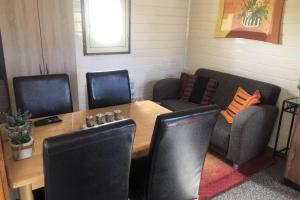 una stanza con tavolo, sedie, tavolo, sedia e tavolo di Blokhut De Vlinder gelegen nabij het Pieterpad a Coevorden