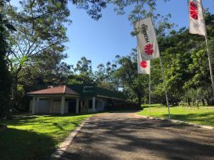 two flags in front of a building at Los Lagos Resort Hotel in Capiatá