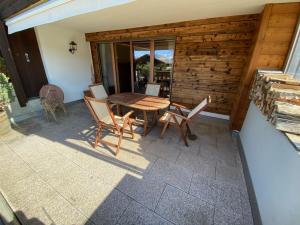 a patio with a wooden table and chairs at Apartment La Berciére 6 in Villars-sur-Ollon