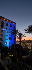 a building with a blue sign on the side of it at Ankars Suites & Hotel in Ramallah
