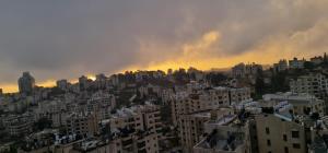 a view of a city at sunset with buildings at Ankars Suites & Hotel in Ramallah