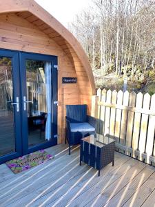 une cabine en bois avec une chaise et une table sur une terrasse dans l'établissement Keepers Pod, à Arisaig