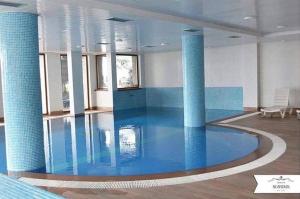 a large pool in a room with blue tiles at Hotel Scardus in Tetovo