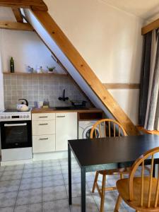 een keuken met een tafel en stoelen en een trap bij Apartament Piwna in Gdańsk