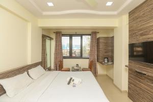 a bedroom with a bed and a large window at Hotel Mid town in Mumbai