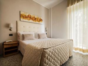 sypialnia z dużym łóżkiem i dużym oknem w obiekcie Hotel Bridge w Rimini