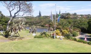 a golf course with a lake in the background at Whalehaven in Southbroom