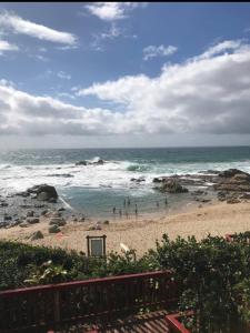 - une plage avec un groupe de personnes dans l'océan dans l'établissement Whalehaven, à Southbroom