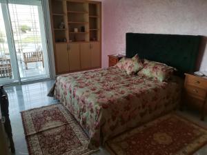 a bedroom with a bed with a green headboard and a bed sidx sidx sidx at Villa avec piscine in Fez