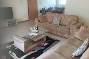 a living room with a couch and a table at BURGUNA Apartment, 500m from Burgau Beach in Burgau