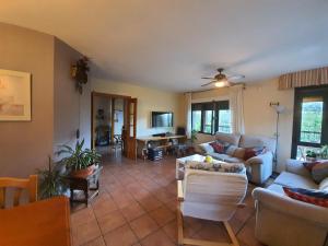 ein Wohnzimmer mit einem Sofa, Stühlen und einem TV in der Unterkunft Casa La Taratola in Ortigosa del Monte
