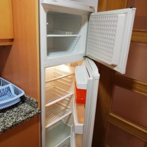 an empty refrigerator with its door open in a kitchen at Apartamento a 50 metros de la playa Muchavista in El Campello