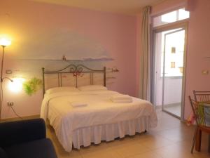 1 dormitorio con 1 cama con colcha blanca en Elisart Guest House, en Alghero
