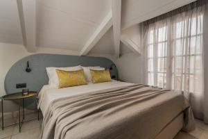 a bedroom with a large bed with yellow pillows at Mavra Elegant Apartments in Zakynthos Town