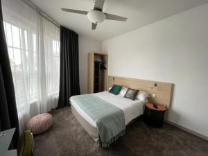 sypialnia z łóżkiem i wentylatorem sufitowym w obiekcie Urban Jungle Hôtel Orleans w Orleanie