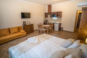 a living room with a large bed and a kitchen at Toscana Apartman in Gyula