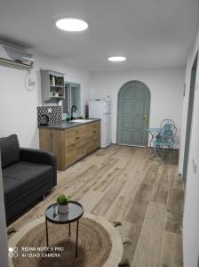 een woonkamer met een bank en een keuken bij בית בלב הגולן in Qatzrin