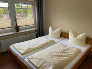 two beds in a room with two windows at Naturcamp Duvendiek FeWo in Duvendiek