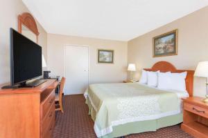a hotel room with a bed and a flat screen tv at Days Inn by Wyndham Princeton in Princeton +18 photos