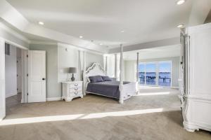 een witte slaapkamer met een bed en een raam bij Sunset Getaway in Ocean City