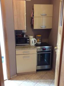 a small kitchen with a stove and a microwave at Apartment next Metro - Adults Only in Warsaw