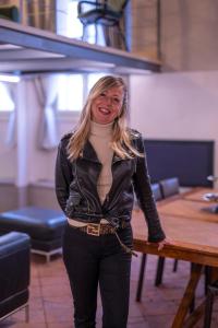 a woman in a leather jacket standing next to a table at BRIXIA LUXORY & LOFT in Brescia