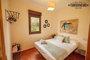 Casa en la playa de Area con finca privada في فيفييرو: غرفة نوم بسرير كبير في غرفة