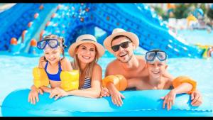 uma família deitada numa jangada numa piscina em Hotel Golden Dolphin com café da manhã! Piscinas 24h em Caldas Novas