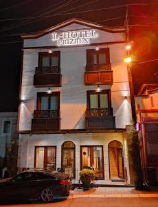 a building with a car parked in front of it at L'Hotel in Prizren