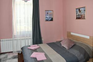 um quarto com uma cama com toalhas cor-de-rosa em Тодоров Дом, Ваканционен дом под наем em Samokov