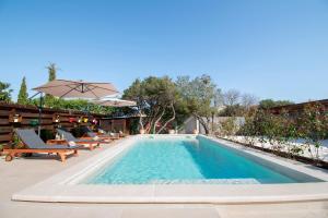 a swimming pool with chairs and an umbrella at Haus Vita in Pula