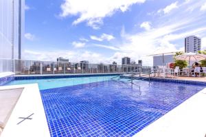 a swimming pool with a pool table and chairs at Bugan Recife Hotel by Atlantica in Recife