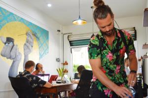 a man standing in a room with a person sitting at a table at Casa Losodeli & Coworking- Adults Only in Puerto Escondido
