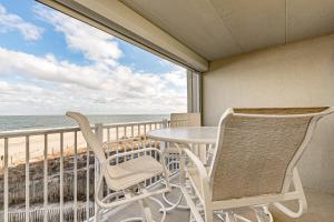 balcón con mesa, sillas y vistas al océano en Pelican Beach, en Ocean City